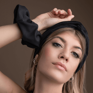 
                  
                    woman holding up hand wearing black corduroy bandeau headband
                  
                